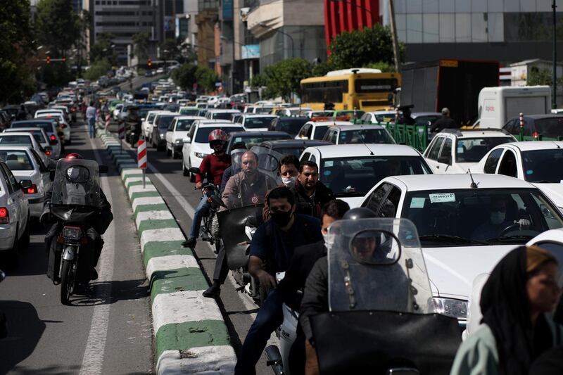 Iranians wear protective face masks ride on their motorbikes in a crowded at street, in Tehran, Iran.  REUTERS