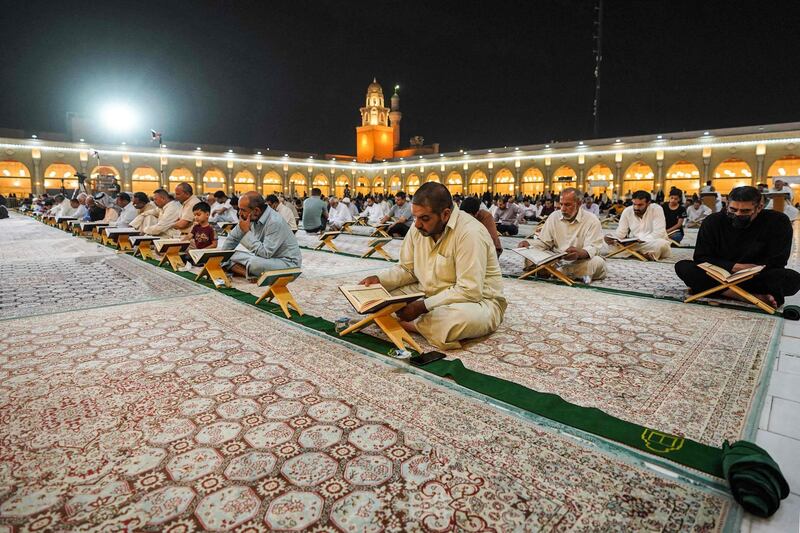 Men read from the Quran at the Grand Mosque of Kufa near the central shrine city of Najaf, about 160 kilometres south of Iraq's capital Baghdad, during the month of Ramadan. AFP