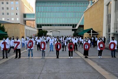epa08877617 Medical students at the American University of Beirut (AUB) carry cutout placards forming the new tuition fee amount of 170 million Lebanese pounds after the adjustment of dollar exchange rate during a protest in Beirut, Lebanon, 11 December 2020. The AUB, one of the oldest universities in the Middle East region, announced it will increase tuition fees in local currency by 160 percent amid the economic crisis in the country. The university will update the exchange rate to 3,900 Lebanese pounds to the US dollar, after it was officially stabilized at 1,500 Lebanese pounds to the dollar 23 years ago.  EPA/WAEL HAMZEH