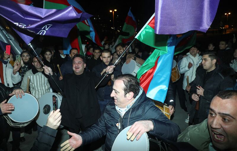 Supporters of Mr Aliyev, Azerbaijan's incumbent president, celebrate following the announcement of exit poll results in Baku. Reuters