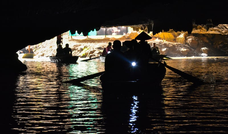 Tourists row down an underground river in Tam Coc.