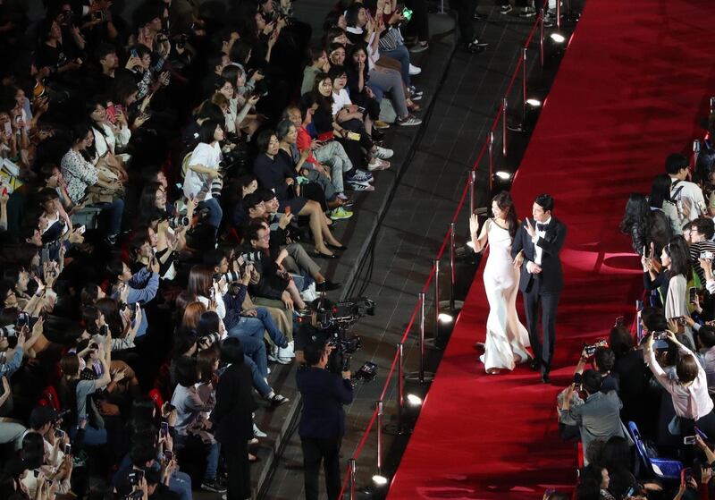 South Korean actor Jung Woo-sung (R) and actress Lee Honey (L) walk on the red carpet during the opening ceremony of the 24th Busan International Film Festival.  EPA