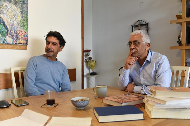 Moshe Shitrit (L) sits at home in Tel Aviv with his brother, Itzhak Shitrit, beside books about Morocco. Rosie Scammell for the National