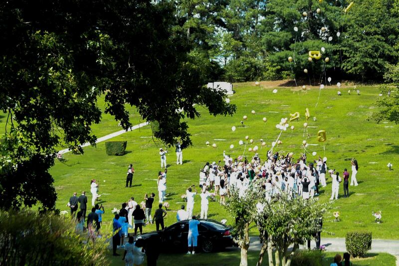 People release balloons at Forest Hills Memorial Gardens cemetery. Reuters