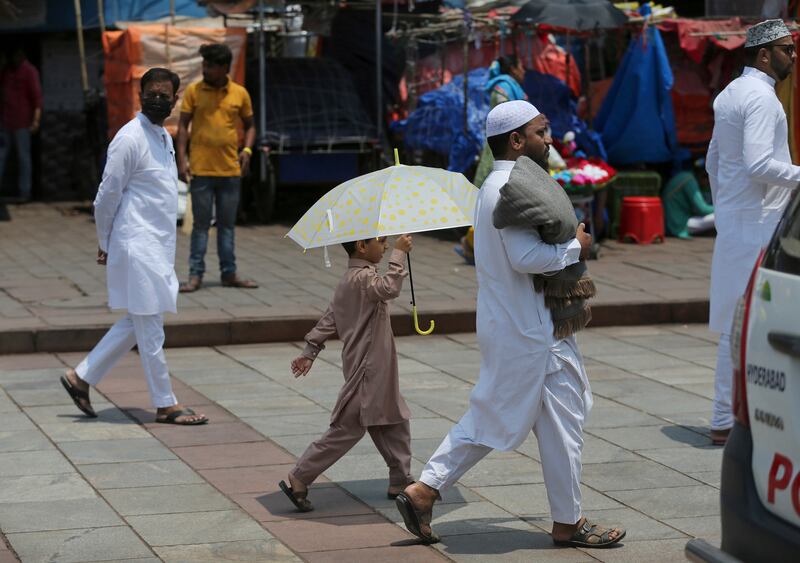 A Muslim boy holds an umbrella to protect himself from the sun  walking towards Mecca Mosque in Hyderabad. AP Photo