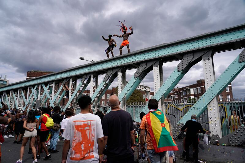 Revellers dance on top of a railway bridge during the carnival. AP