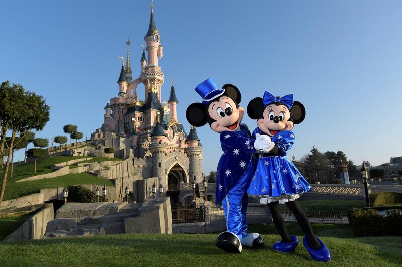 Disney characters Mickey and Mini mouse pose in front of the Sleeping Beauty Castle to mark the 25th anniversary of Disneyland - originally Euro Disney Resort - on March 16, 2017 in Marne-La-Vallee, east of the French capital Paris. - The 25th anniversary celebrations will begin on March 26, 2017 with parades, various shows and a firework's display. (Photo by BERTRAND GUAY / AFP)