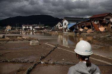 A woman looks at homes devastated by Typhoon Hagibis Tuesday, Oct. 15, 2019, in Nagano, Japan. AP