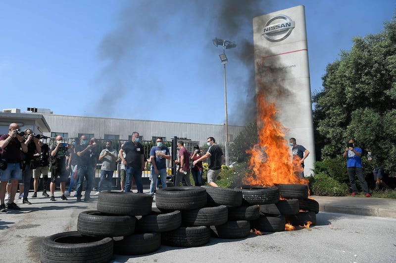 TOPSHOT - Nissan employees burn tyres in front of the Japanese cars manufacturer's plant in Barcelona on May 28, 2020, as they protest against the factory closure. Japanese carmaker Nissan has decided to shut its factory in Barcelona where 3,000 people are employed, the Spanish government said today. / AFP / LLUIS GENE
