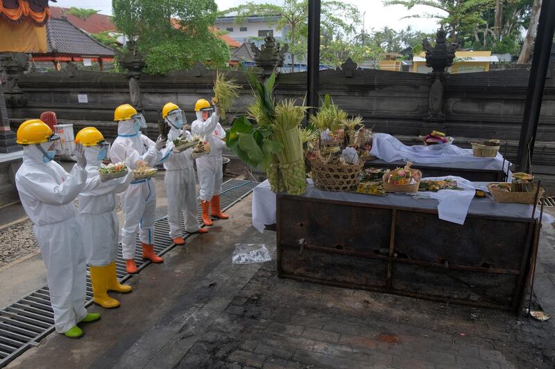 Officials wearing personal protective equipments (PPE) pray for the bodies of people who died due to the coronavirus disease at a crematorium in Bangli, Bali, Indonesia. REUTERS