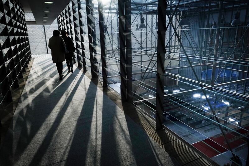 People walk in outside corridor over the Vip arrival area of the European Council building as sun falls down in Brussels, Belgium.  EPA