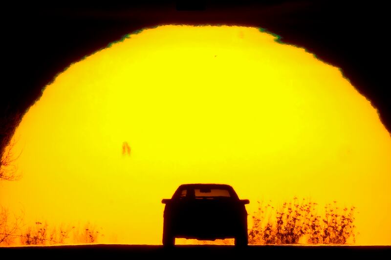 A motorist is silhouetted against the setting sun on the eve of the vernal equinox, Sunday, March 19, 2023, in Shawnee, Kan.  The equinox marks the beginning of spring in the northern hemisphere with the day and night being roughly equal in duration.  (AP Photo / Charlie Riedel)