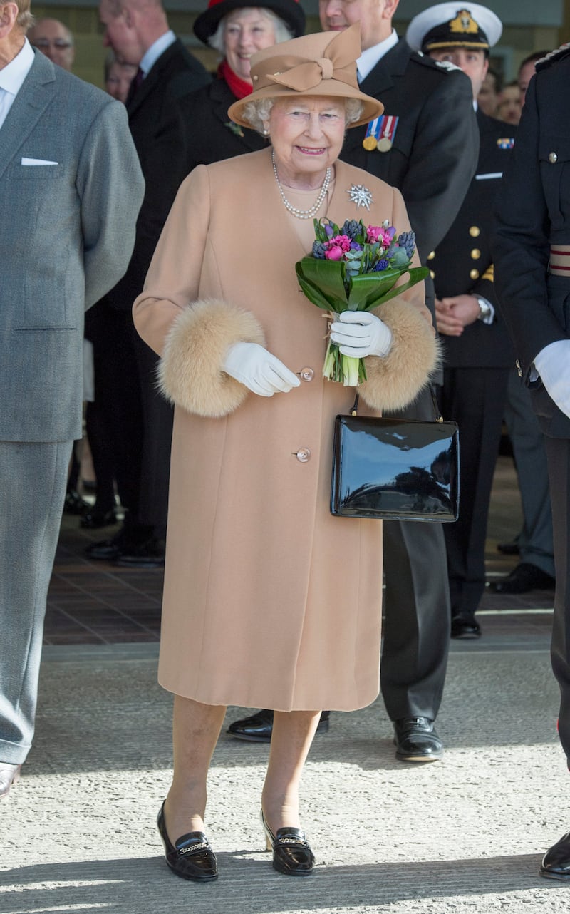 Queen Elizabeth II, wearing peach, formally opens the new South Lynn Fire Station on February 2, 2015, in King's Lynn, Norfolk, England. Getty Images