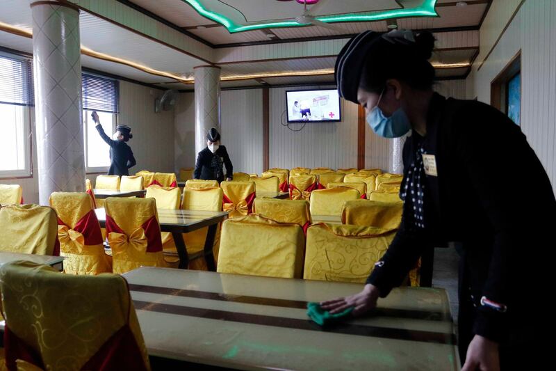 Staff of the Pongnam Noodle House disinfect the tables and windows of the restaurant in Pyongyang. AP Photo