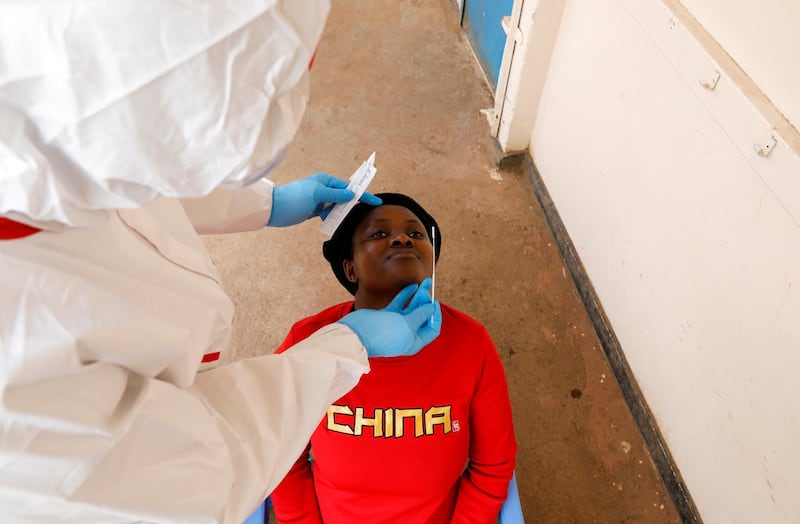 A health worker takes a swab from a woman during a mass testing in an effort to stop the spread of coronavirus in the Kibera slum of Nairobi, Kenya. Reuters