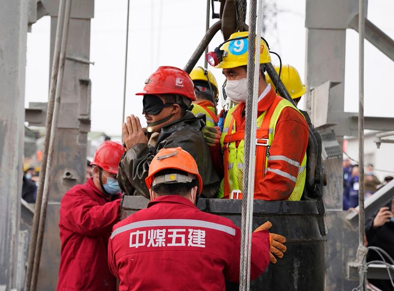 A miner wearing a black eyepatch is saved from hundreds of metres underground. AFP