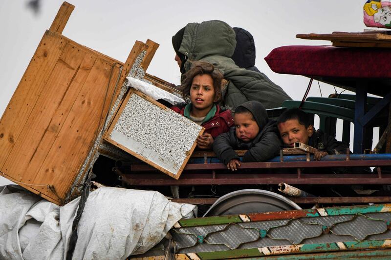 Children ride in the back of a lorry loaded with household goods in the west of Syria's Aleppo province as civilians flee advancing Syrian government forces. AFP