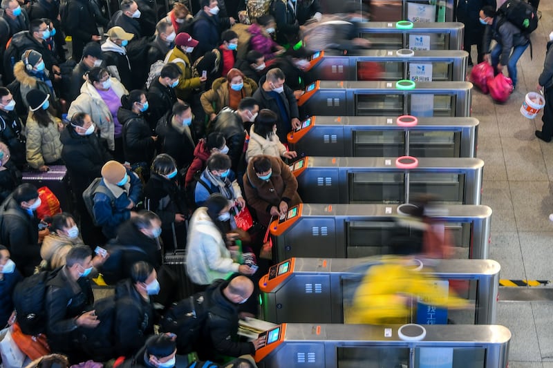 People wearing masks rush to catch their trains in Suzhou, a city in eastern China's Jiangsu province. This Lunar New Year public holiday, which officially begins on January 21, will be the first since 2020 without coronavirus travel restrictions. Xinhua via AP