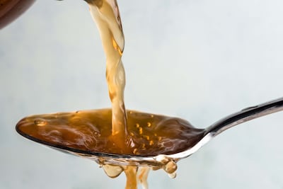Close-Up Of Vinegar Pouring In Spoon. Getty Images