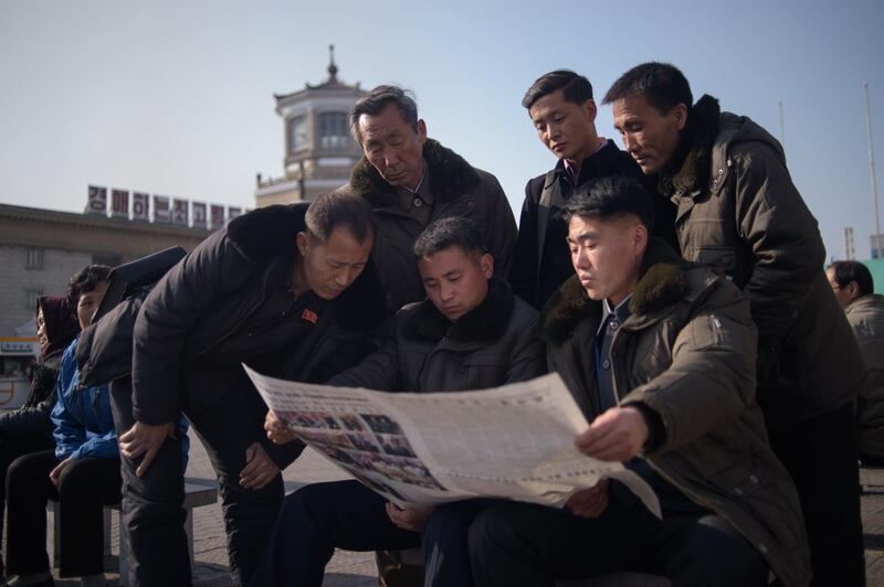 CORRECTION / People read the Rodong Sinmun newspaper showing coverage of North Korea's leader Kim Jong Un visiting Vietnam for a summit in Hanoi with US President Donald Trump, in a public square in Pyongyang on February 28, 2019. The US-North Korea nuclear summit in Hanoi ended abruptly without a deal, with President Donald Trump saying he had decided to "walk" in the face of Kim Jong Un's demands to drop sanctions.
 / AFP / Kim Won Jin
