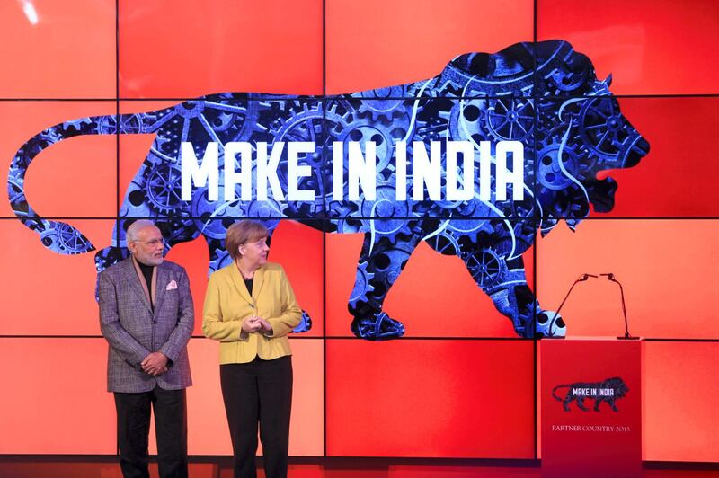 Angela Merkel, Germany's chancellor, right, and Narendra Modi, India's prime minister, stand on stage as a "Make In India" logo is displayed at the Hanover industrial fair in Hanover, Germany, on Monday, April 13, 2015. Modi said "huge" opportunities await German industry as he seeks to roll back barriers to foreign investment and speed up growth in Asia's third-biggest economy. Photographer: Krisztian Bocsi/Bloomberg *** Local Caption *** Narendra Modi; Angela Merkel