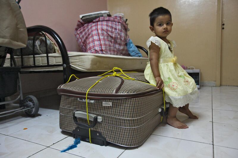 Dubai, UAE, July 8, 2012:
Fatimah Sabir, all of 2 years old, is seen here resting on a suitcase in her home.

The residents of the area were told on June 1st via text message that they would have to vacate their homes by mid july at the very latest. 

Lee Hoagland/The National