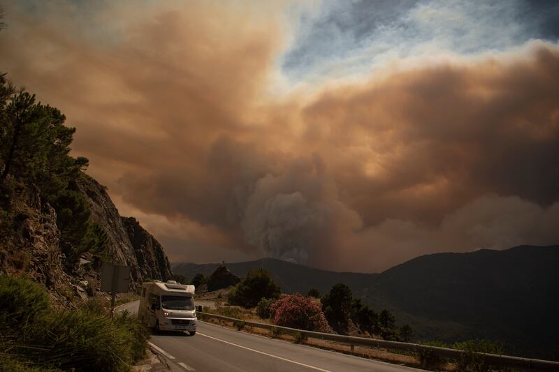 TOPSHOT - Smoke from a wildfire in Sierra Bermeja mountain range in Malaga is pictured from Benahavis on June 9, 2022.  - Around 2,000 people were evacuated overnight as a fire raged through a forested area of southern Spain in an area badly hit by wildfires just nine months ago, rescuers said today.  (Photo by JORGE GUERRERO  /  AFP)