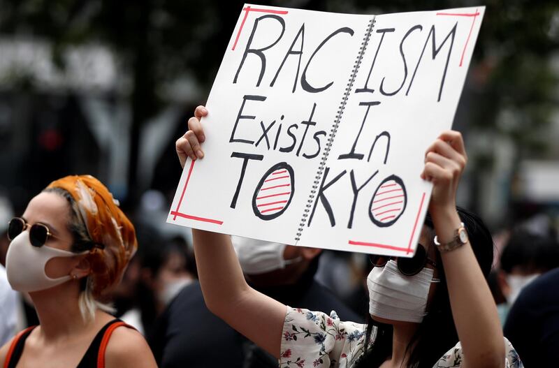 A demonstrator wearing a mask holds a placard during a protest march over the alleged police abuse of a Turkish man, in echoes of a Black Lives Matter protest, following the death of George Floyd who died in police custody in Minneapolis, in Tokyo, Japan.  Reuters