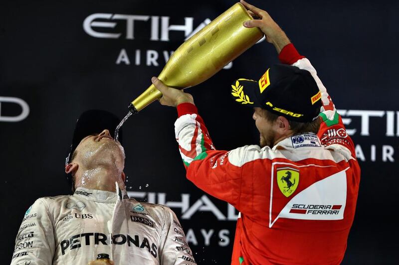 Sebastian Vettel pours rose water over Nico Rosberg. Clive Mason / Getty Images
