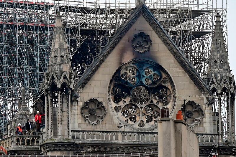 Inspectors are seen on the roof of the landmark Notre-Dame Cathedral in central Paris on April 16, 2019, the day after a fire ripped through its main roof.  A major fire broke out at the landmark Notre-Dame Cathedral in central Paris sending flames and huge clouds of grey smoke billowing into the sky, the fire service said. The flames and smoke plumed from the spire and roof of the gothic cathedral, visited by millions of people a year, where renovations are currently underway.                         / AFP / Lionel BONAVENTURE
