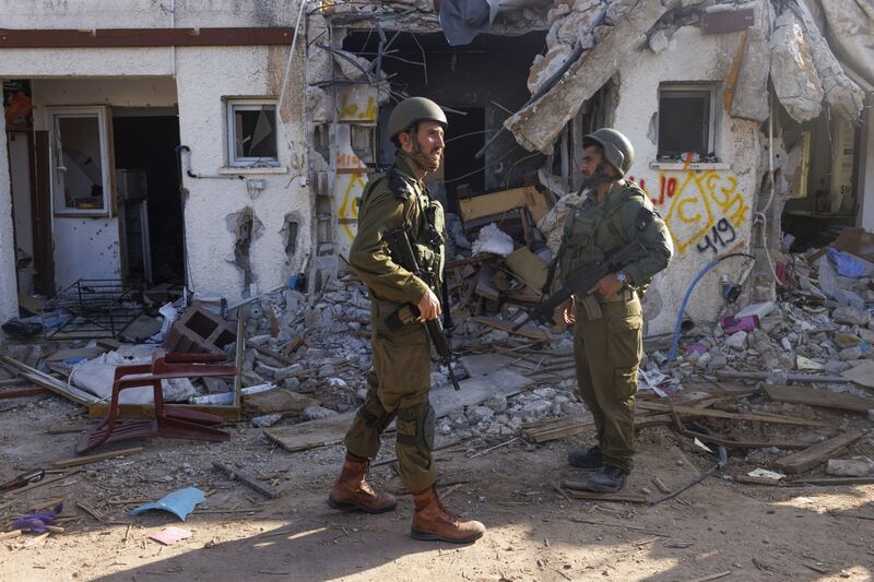 Israeli soldiers patrol outside a house destroyed during fighting with Hamas militants, in the kibbutz of Kfar Aza. Bloomberg