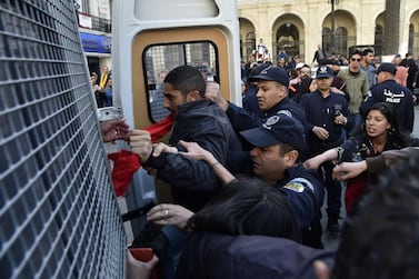 Algerian policemen detain protesters after they demonstrated at Emir Abdelkader square in the capital Algiers. AFP