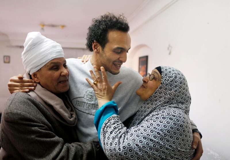 Mahmoud Abu Zaid, center, a photojournalist known as Shawkan, is hugged by his parents at his home in Cairo, Egypt, Monday, March 4, 2019. Shawkan was released after five years in prison. (AP Photo/Amr Nabil)