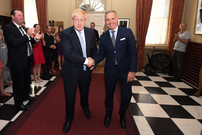 (FILES) In this file photo taken on July 24, 2019 Britain's Prime Minister Boris Johnson (CL) shakes hands with Cabinet Secretary Mark Sedwill (CR), Head of the Civil Service, as he is clapped into 10 Downing Street in London on July 24, 2019 by Mark Spencer (L) and Johnson's special advisor Dominic Cummings (R) among other staff after he accepted the invitation from Queen Elizabeth II to become Prime Minister and form a new government.  Mark Sedwill has announced on June 28, 2020 he will stand down from his role as Cabinet Secretary, National Security Adviser and head of the Civil Service in September 2020. / AFP / POOL / Stefan Rousseau
