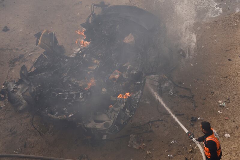 A rescuer puts out a fire after a car was hit by an Israeli strike in Rafah in the southern Gaza Strip. Reuters 