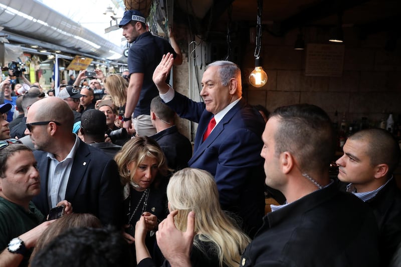 Benjamin Netanyahu waves to supporters as he tours the Mahane Yehuda market. EPA