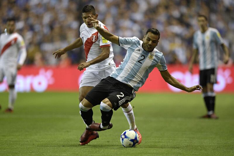 Argentina's Gabriel Mercado (R) is marked by Peru's Edison Flores during their 2018 World Cup qualifier football match in Buenos Aires on October 5, 2017. / AFP PHOTO / Juan MABROMATA