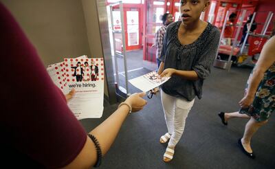 In this Friday, Oct. 13, 2017, photo, a potential job candidate takes a flyer from a human resources representative at a Target store in Dallas. The U.S. government issues the October jobs report, Friday, Nov. 3, 2017. (AP Photo/LM Otero)