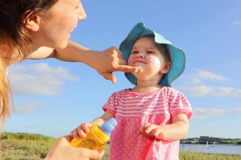 Mother putting sun cream on toddler girl. Getty Images