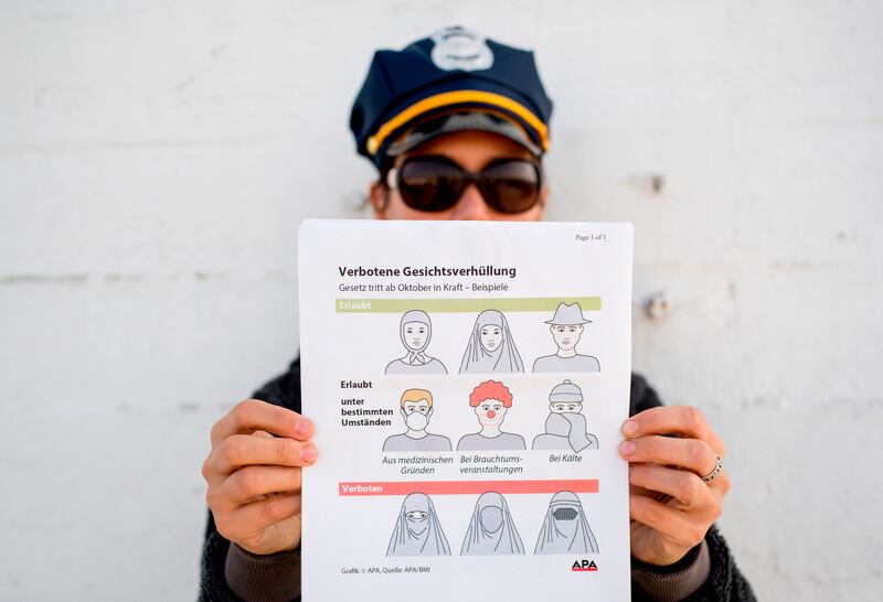 This illustration photo shows a model holding up an information pamphlet about new Austrian restrictions banning the wearing of burqas and other items covering the face in public places and buildings, in Vienna, Austria on September 29, 2017.
The new restrictions come into force in Austria on October 1, 2017 banning the wearing of the full Islamic veil and other clothes concealing the face in public places and buildings. Exemptions "under certain conditions" include items like clown disguises "at cultural events", work wear such as medical masks, and scarves in cold weather, the government says. / AFP PHOTO / JOE KLAMAR