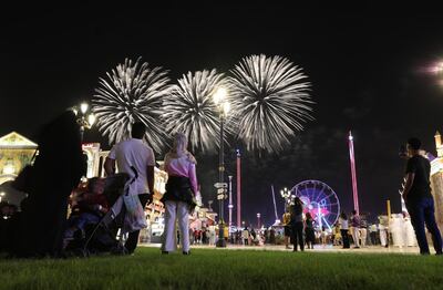 epa08773412 Visitors look on fireworks at the Global Village in Dubai, United Arab Emirates, 25 October 2020. The 25th edition of the Global village is running from 25 October 2020 till 18 April 2021. This edition is including 78 cultures represented in 26 pavilions and 3,500 outlets with taking all safety precautions to avoid the spreading of COVID-19.  EPA/ALI HAIDER