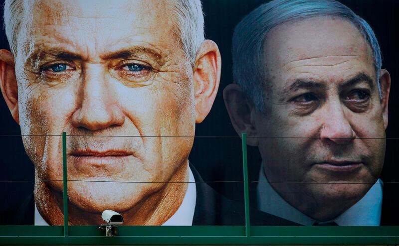 (FILES) In this file photo taken on February 17, 2020 (FILES) A file photo taken on February 17, 2020 shows an election banner for the Israeli Blue and White political alliance (Kahol Lavan) with the face of (L to R) its leader retired army general Benny Gantz and Prime Minister Benjamin Netanyahu, hanging in Ramat Gan. Israeli Prime Minister Benjamin Netanyahu and his former rival, parliament speaker Benny Gantz, agreed to form an emergency unity government on April 20, 2020, ending the worst political crisis in the country's history. / AFP / JACK GUEZ
