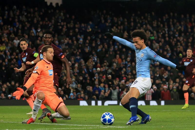 Manchester City's German midfielder Leroy Sane (R) shoots past Hoffenheim's German goalkeeper Oliver Baumann to score their second goal during the UEFA Champions League group F football match between Manchester City and Hoffenheim at the Etihad stadium in Manchester, north west England on December 12, 2018.  / AFP / Lindsey PARNABY
