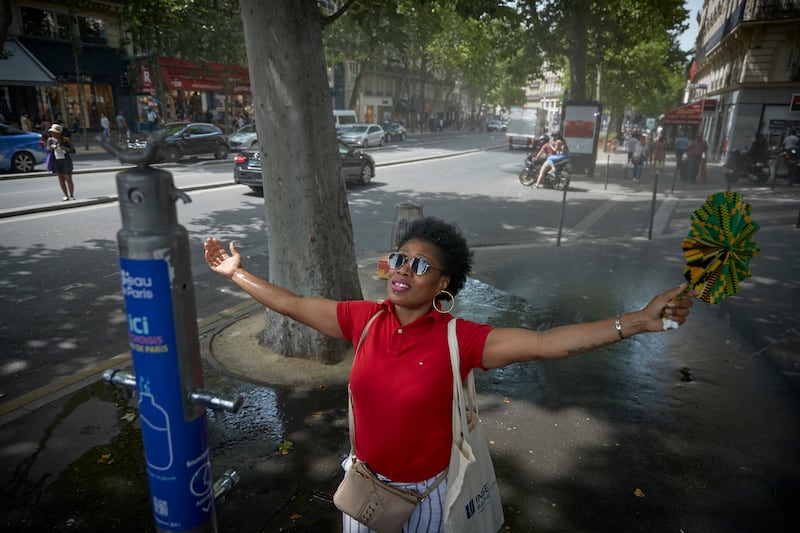 Parisians cool down at a water station in June 2022