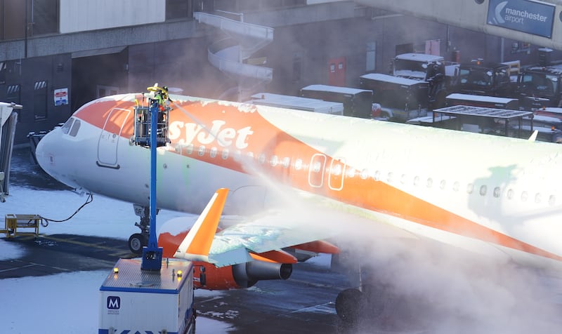 A plane is de-iced at a the airport, in England. PA