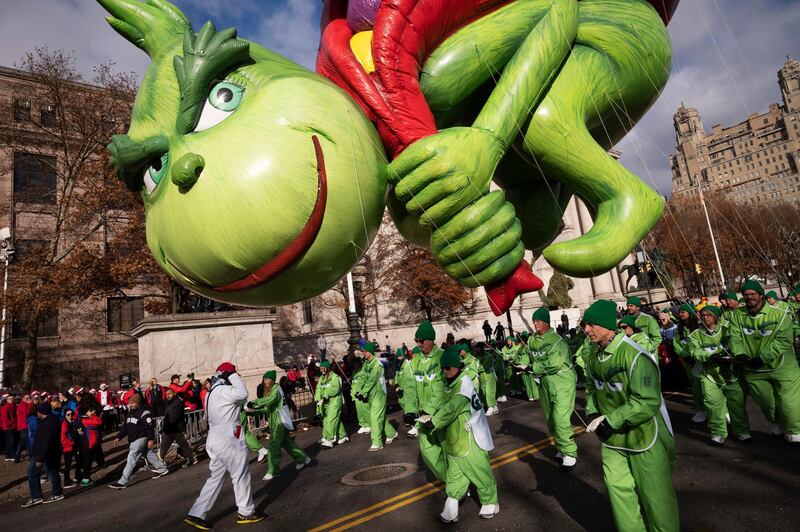 Balloon handlers hold Dr. Seuss' The Grinch close to the ground as strong winds affect the Macy's Thanksgiving Day Parade , in New York.  AP