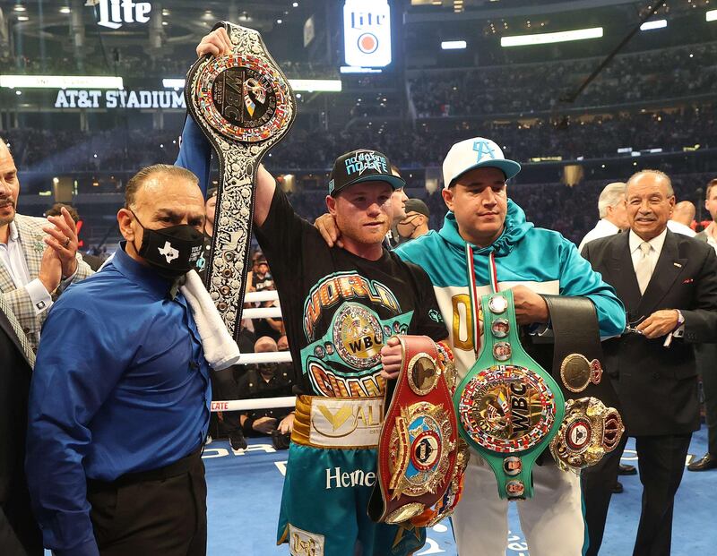 Saul Alvarez lifts the belts after defeating Billy Joe Saunders who did not answer the bell for the eighth round in their super middleweight title fight. AFP