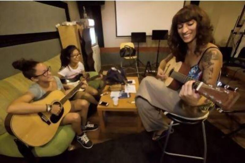 Striking a chord: left to right, Sasha Hattar, 15, and Erika Hayashi, 15, practise playing guitar with Dubai-based musician Noush Like Sploosh, ahead of the week-long Rock Camp for Girls project in Dubai. Photos by Jaime Puebla / The National