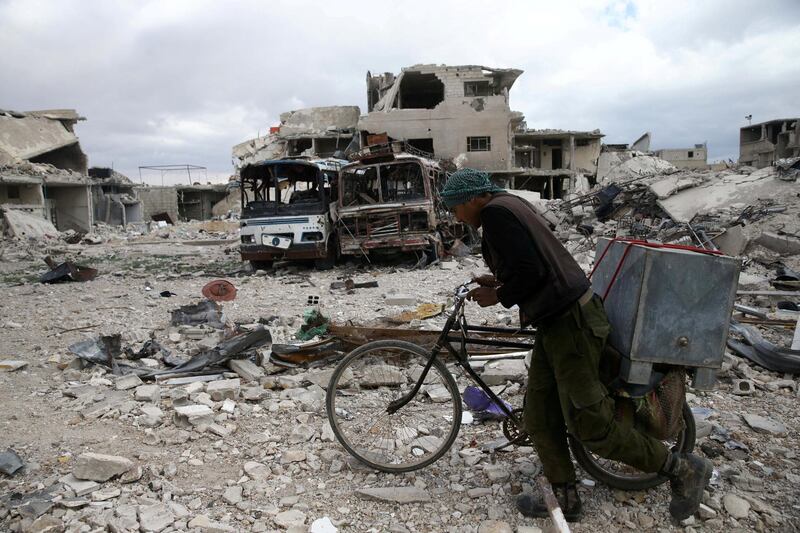 A man walks with his bicycle at a damaged site in the besieged town of Douma, Eastern Ghouta, in Damascus, Syria March 30, 2018. REUTERS/Bassam Khabieh     TPX IMAGES OF THE DAY