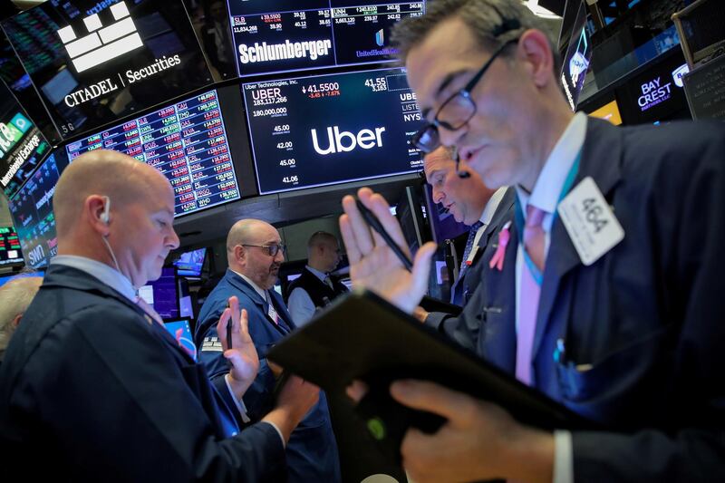 FILE PHOTO: Traders work near the post where Uber is traded on the floor at the New York Stock Exchange (NYSE) in New York, U.S., May 10, 2019. REUTERS/Brendan McDermid/File Photo